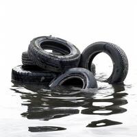Old tires polluting a lake representing environmental problems photo