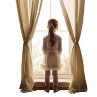 Little girl with long hair looking out of window photo