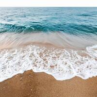 Ocean waves crashing on sandy beach creating white foam photo
