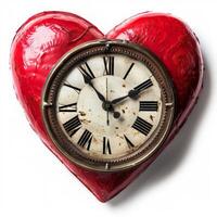 Red heart shaped clock showing almost five o'clock on white background photo