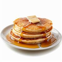 Stack of pancakes with melting butter and dripping syrup on white background photo