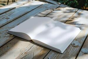 Open book lying on rustic wooden table in garden setting photo