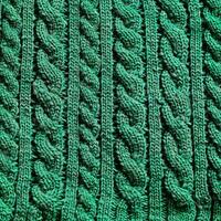 Green cable knit fabric texture creating repeating pattern photo
