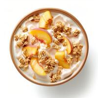 Bowl of yogurt topped with fresh peach slices, granola and honey drizzle photo