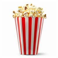 Popcorn overflowing a red and white striped cardboard container photo