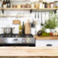 Empty wooden table in front of blurred kitchen background photo