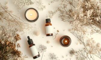 Three bottles of perfume are on a table with a candle and some flowers photo