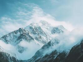 Majestic Snow-Capped Peaks Cloaked in Misty Clouds photo