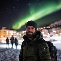 Man Gazing at the Aurora Borealis in a Snowy Town photo