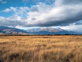 Majestic Mountains Overlook Golden Grassy Field photo