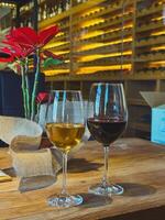 Wine Glasses Filled with Red and White Wine in a Wine Cellar Setting photo