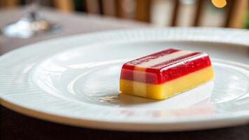 A single piece of candy on a white plate with a shallow depth of field photo