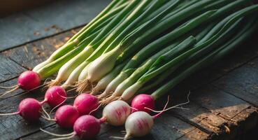 Fresh green onions and radishes arranged on a dark rustic wooden surface with ample copy space for text highlighted by natural lighting. photo