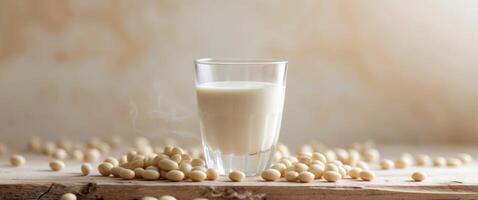 Soy milk in a glass and soy beans on a wooden background photo