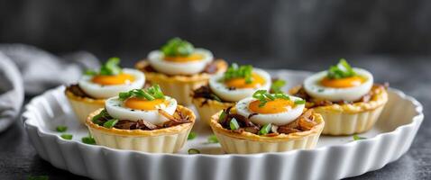 Mini Quiches with Eggs Onions and Cheese Topped with Green Onions in White Dish on Dark Background photo