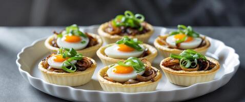 Mini Quiches with Eggs Onions and Cheese Topped with Green Onions in White Dish on Dark Background. photo