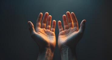 Open Hands Reaching Upward with Soft Lighting and Dark Background. photo