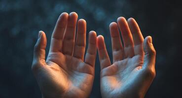 Open Hands Reaching Upward with Soft Lighting and Dark Background photo