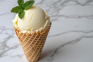 A scoop of vanilla ice cream in a waffle cone, garnished with mint photo