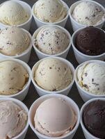 Scoops of delicious ice cream in white cups photo