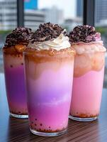 Three colorful bubble tea drinks with whipped cream and chocolate topping photo