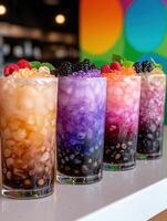 Close up of four colorful bubble tea drinks with various toppings photo
