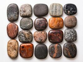 Collection of smooth, colorful stones arranged in a grid pattern photo