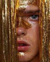 Close up of a mans face partially covered with gold leaf photo