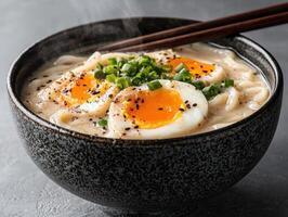 Steaming bowl of udon noodle soup with soft boiled eggs photo