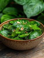 Close up of a delicious spinach salad with sesame seeds and almonds photo