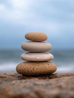Balanced stones on a beach with a blurred ocean background photo