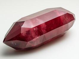 polished ruby gemstone displays rich red hue exhibiting flawless facets reflect soft lighting enhancing its clarity and brilliance on white backdrop photo