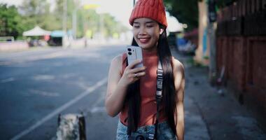 Handheld shot, Happy woman smiling and enjoying mobile phone while walking on the sidewalk in the city. Enjoy the moments during journey video