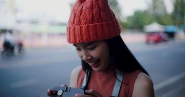 Mano selectivo atención disparo, joven mujer en pie mirando a fotos desde su cámara en un acera en el ciudad. disfrutar el momentos durante viaje video