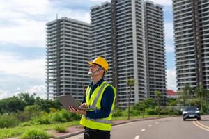 A construction manager evaluates plans near a developing site in an urban setting. photo