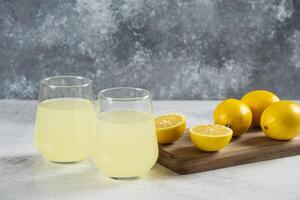 two glasses of lemonade on a cutting board photo