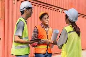 Logistics engineering team discussing project plans in a construction site with plans and tools photo