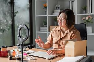 Young woman engaging with her audience while livestreaming skincare cream sales from a bright home office photo
