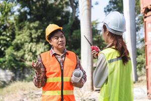 Logistics engineering team discussing project challenges using a walkie-talkie at a construction site photo
