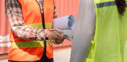 Construction professionals shaking hands on-site, discussing project plans and collaboration photo