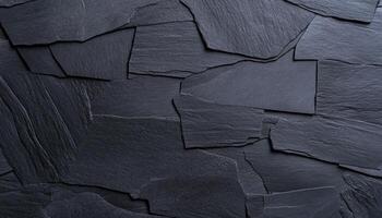 Dark slate pieces arranged in a random pattern create a unique wall texture photo