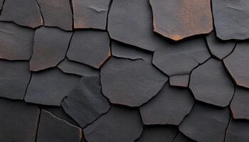 Close view of a black rock surface exhibiting unique textures and irregular shapes photo