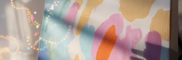 Canvas with abstract colorful paint splashes and shadow of paintbrush photo