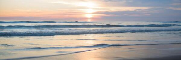Blurred sunset at beach with warm light and gentle bokeh from waves photo