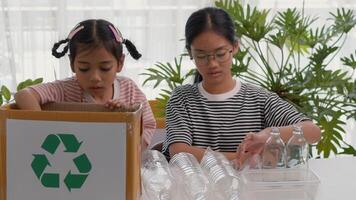 Asian siblings recycle household waste, Protect nature and save the environment. children learn to sort garbage by putting plastic bottles in the recycle photo