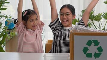 Asian siblings recycle household waste Protect nature, and save the environment children learn to sort garbage by putting plastic bottles in the recycle photo
