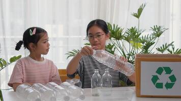 Asian siblings recycle household waste Protect nature and save the environment children learn to sort garbage by putting plastic bottles photo