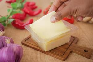 Fresh Slice of Cheese with Vegetables on Wooden Table photo