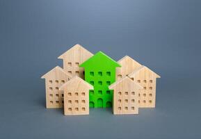 The green building stands out among the houses. Environmentally friendly, energy efficient and zero carbon emissions. Search for the best option to buy an apartment. Net Zero Carbon neutrality. photo
