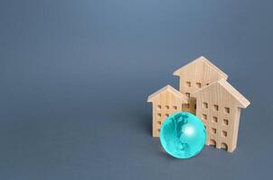 Residential buildings and blue globe. Environmentally friendly housing, minimal impact on environment. Energy efficiency, zero carbon emissions. Carbon neutrality. Internet service communication. IoT photo